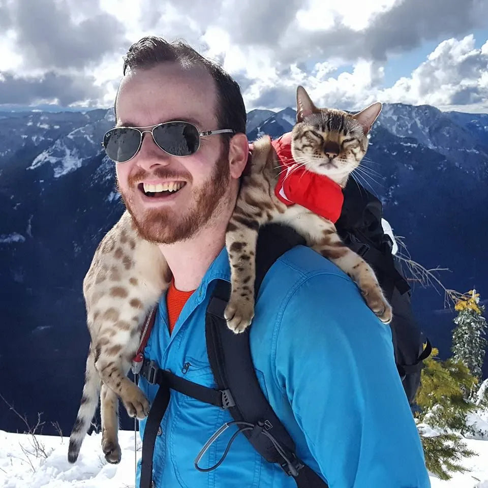 homme avec un chat sur son dos 